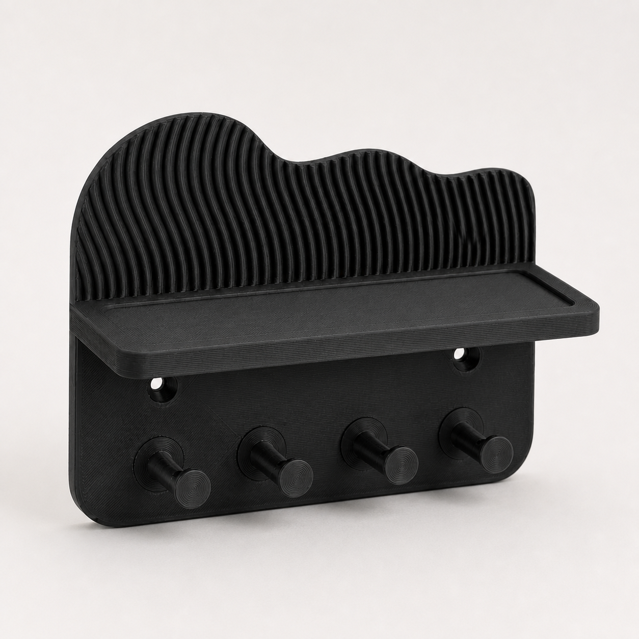 Black key holder with shelf and four hooks against a light background