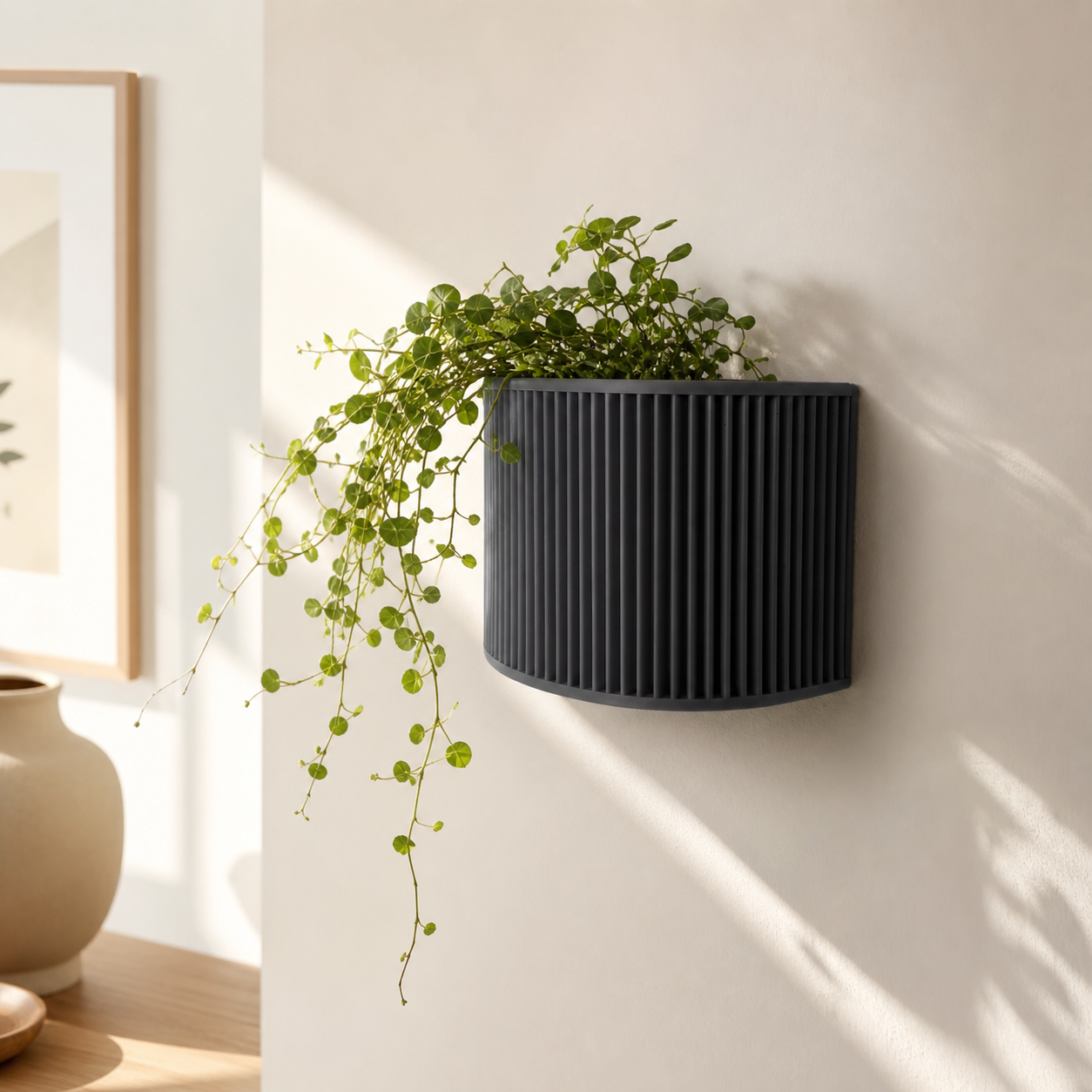 Ribbed wall planter – black planter with a green plant